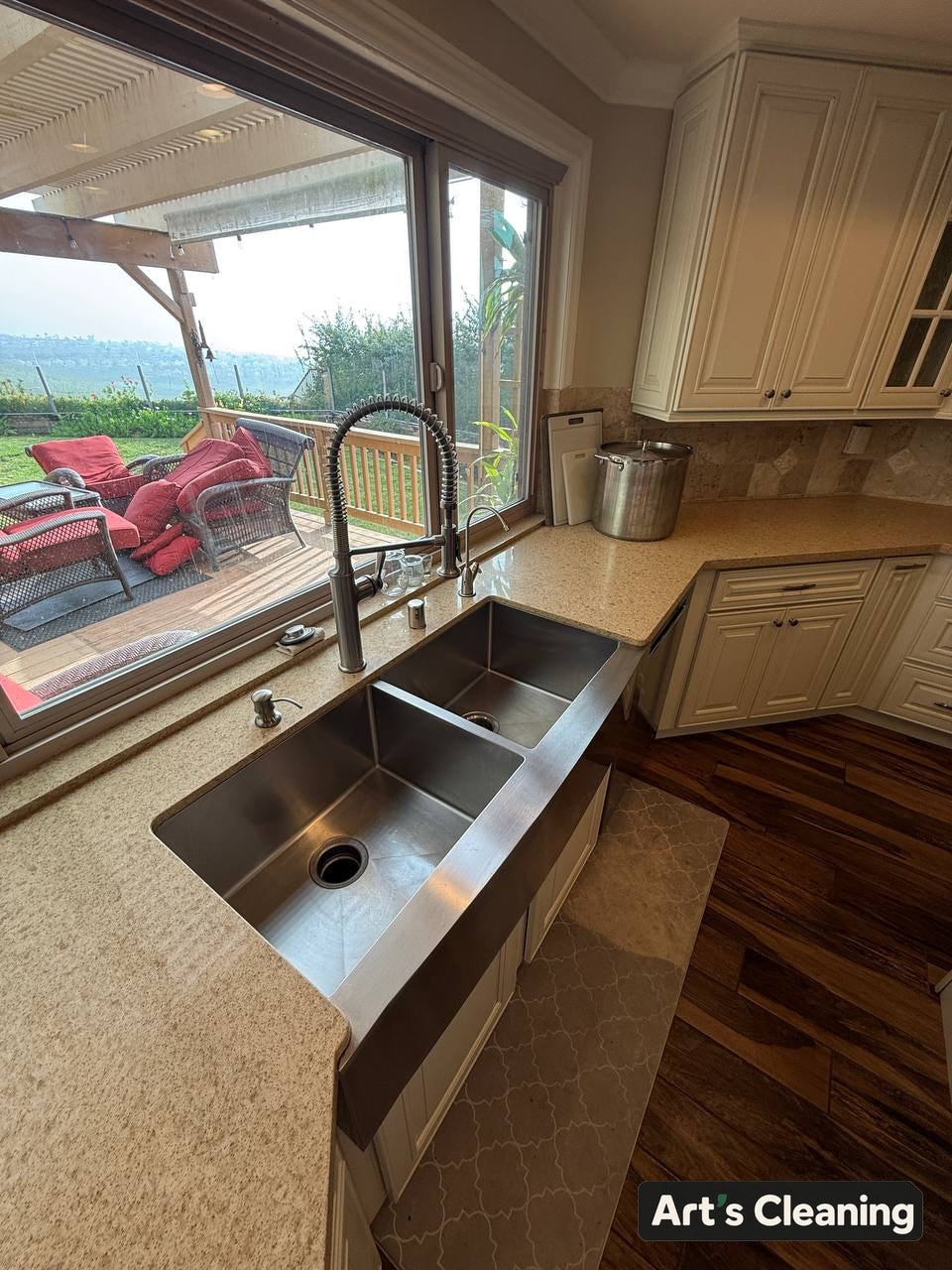 Clean kitchen sink and counter beneath a window
