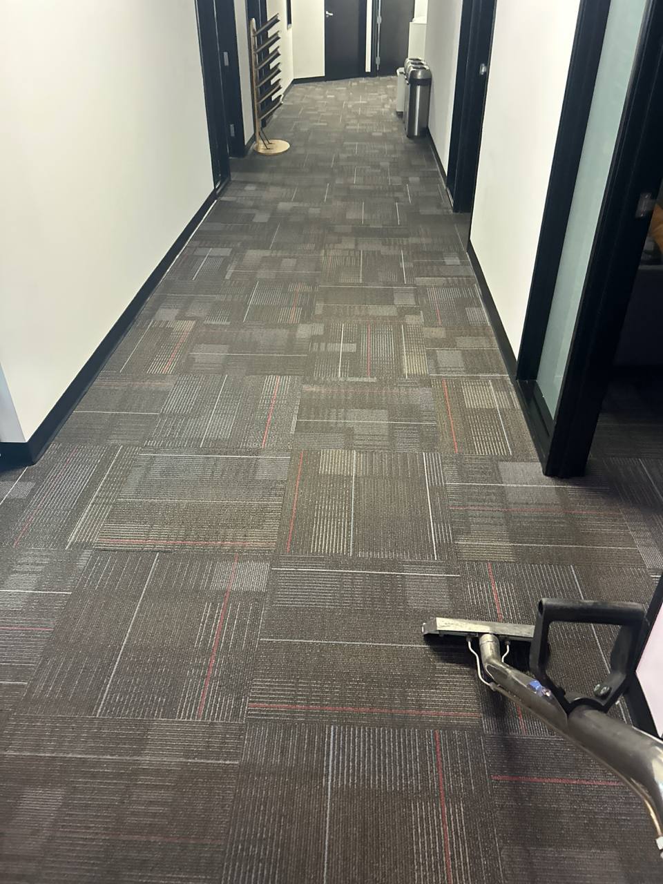 Commercial carpet cleaning in progress in an office hallway